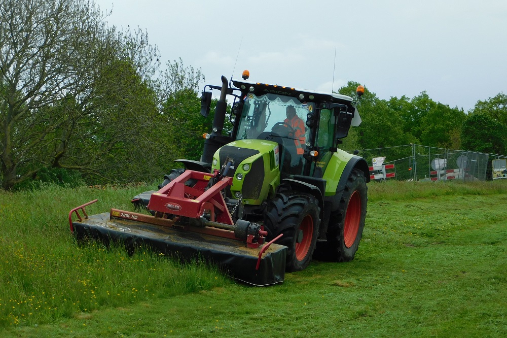 Medewerker Johan van de Steege van Van der Weerd Grafhorst BV maait met de Bolex-maaiers in opdracht van Waterschap Drents Overijselse Delta in de wijk Holtenbroek in Zwolle